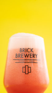 Brick Raspberry & Thyme Sour in branded glass